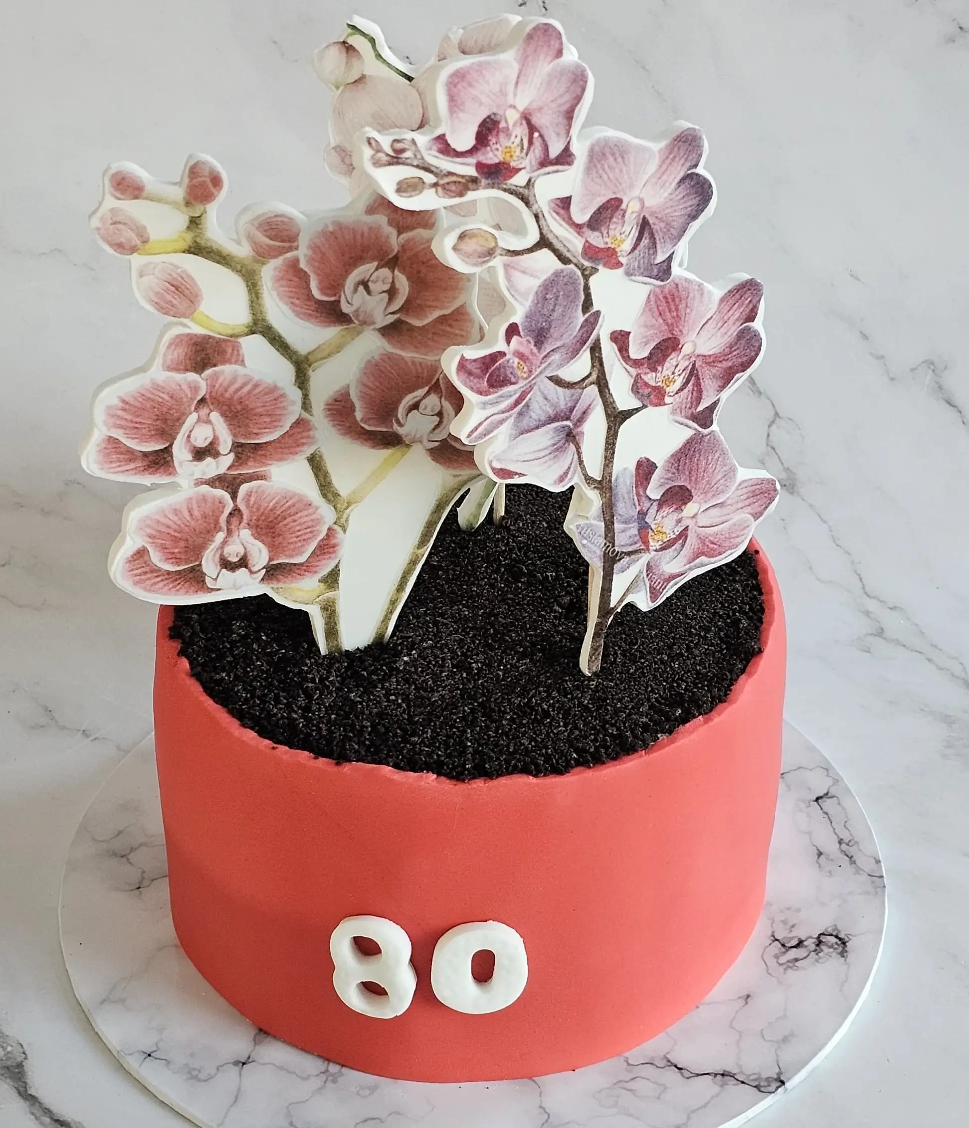 Een taart met bloemen en de cijfers 80 er op